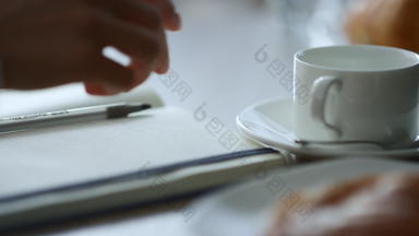 女人手采取笔记写作业务的想法记事本坐着咖啡馆的地方